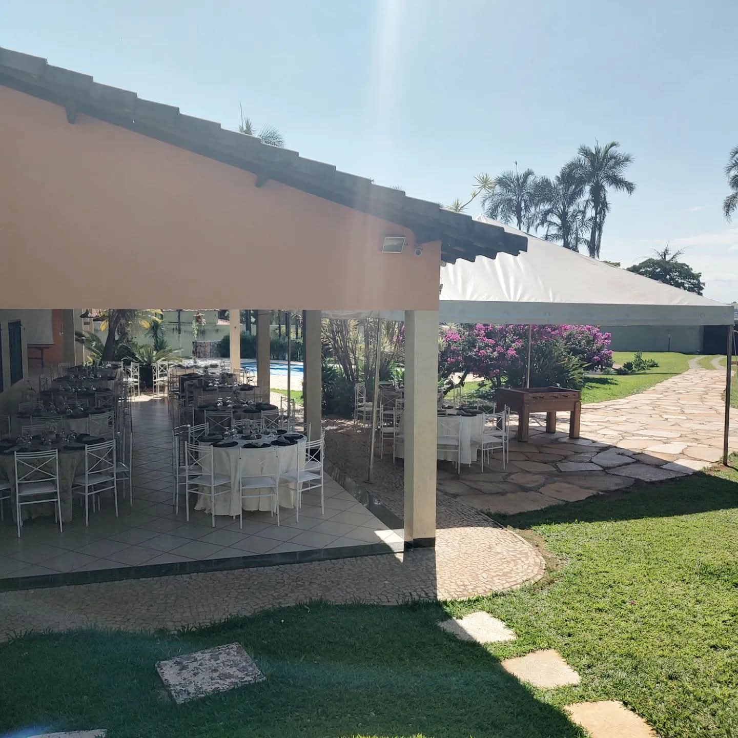 Salão com mesas montadas e vista da piscina